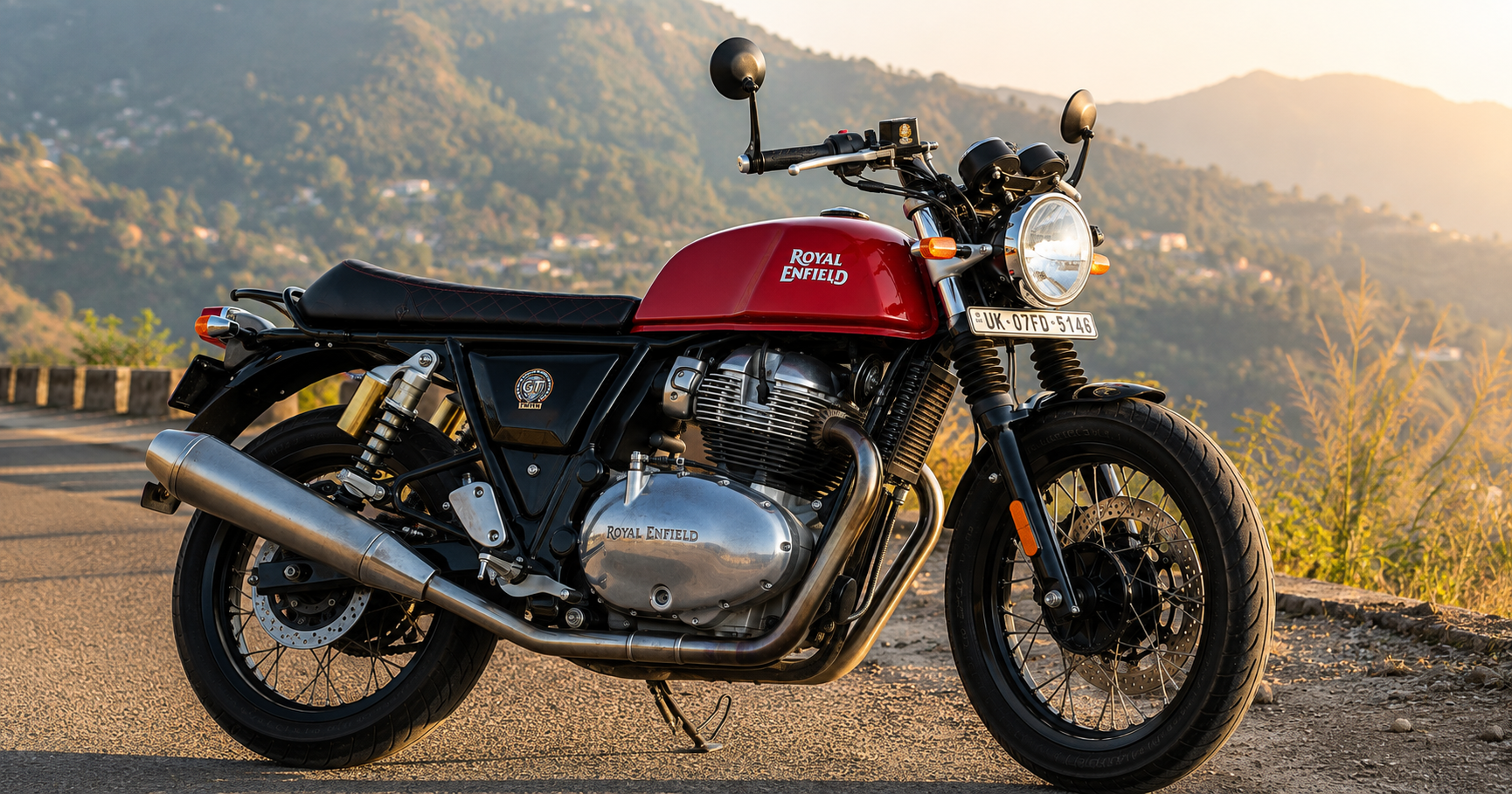 Red Royal Enfield Continental GT 650 on a mountain road at sunset.