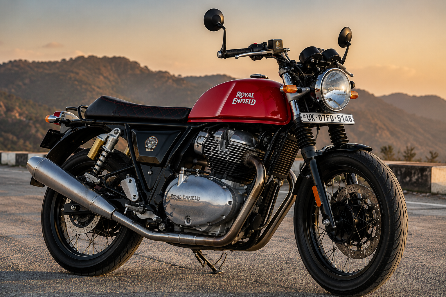 Red Royal Enfield Continental GT 650 Red Rooster at a mountain viewpoint during sunset.