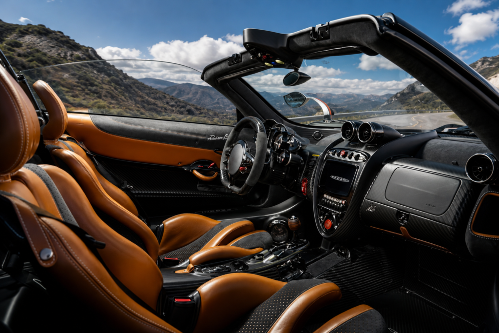 Luxury Pagani Huayra Roadster interior featuring premium leather seats, carbon fiber, and mountain backdrop.
