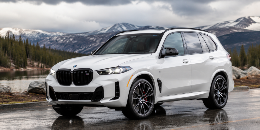 White BMW SUV on scenic mountain road with luxury background