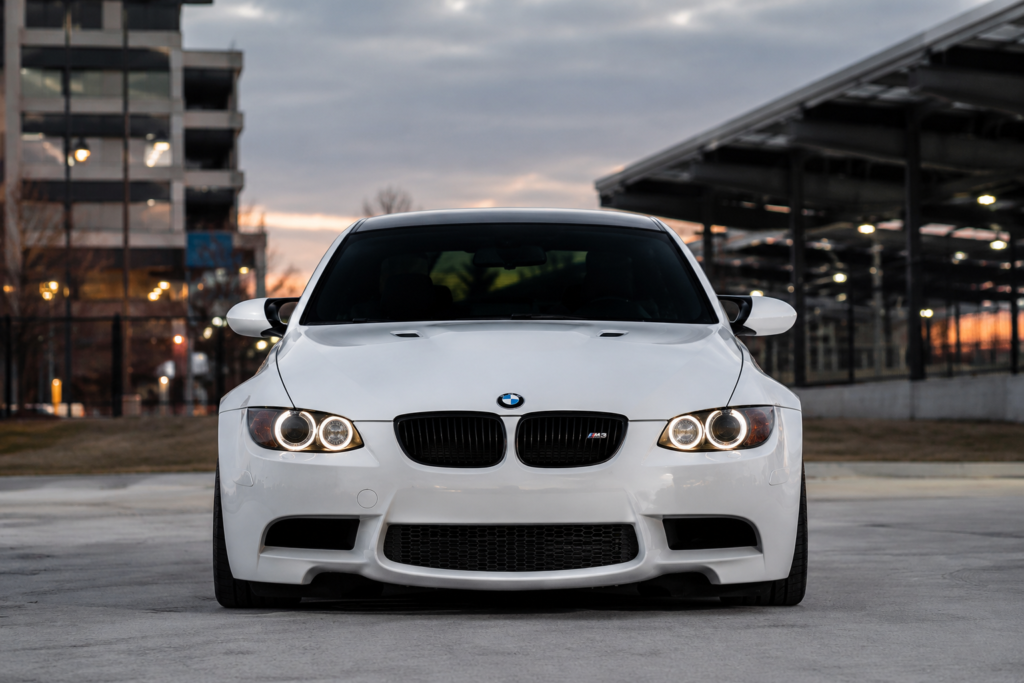 White BMW M3 at sunset with city skyline